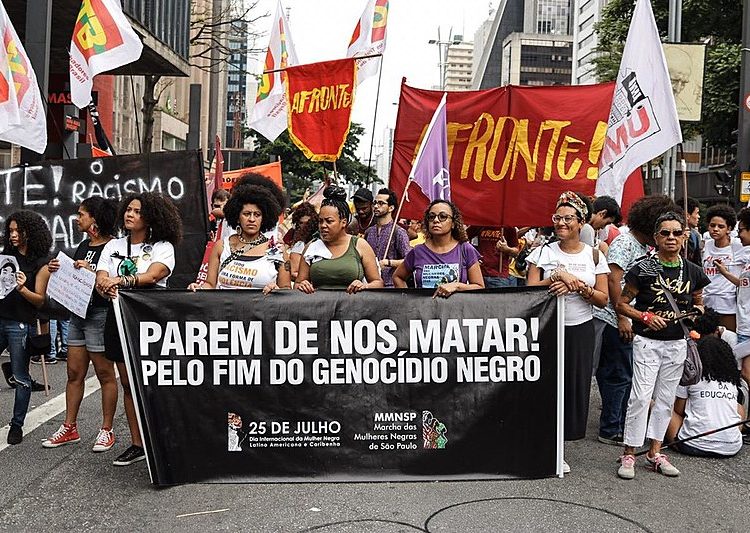 Marchers hold banner that reads "Stop killing us! For the end of black genocide" during demonstration in São Paulo on Nov. 20