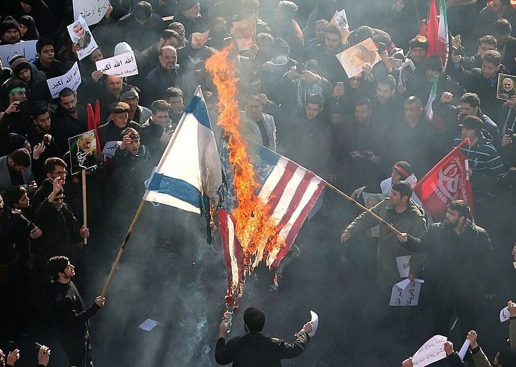 Manifestantes iranianos queimam as bandeiras dos Estados Unidos e de Israel, em Teerã