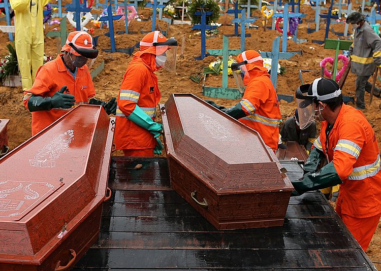 Caixões sendo descarregados para serem enterrados em uma vala comum no cemitério de Nossa Senhora em Manaus, estado da Amazônia, Brasil, em 6 de maio de 2020
